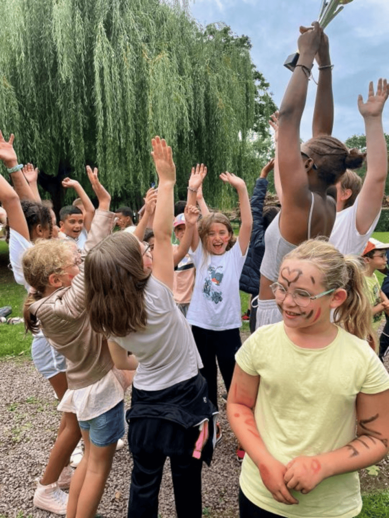 enfants dans un parc avec les mains en l'air