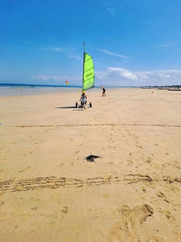 une personne est sur la plage avec un char à voile